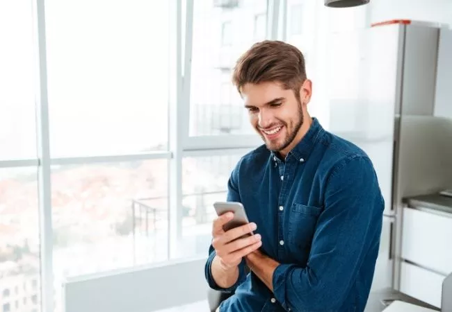 PMann schaut auf sein Smartphone und seine Firmen-App